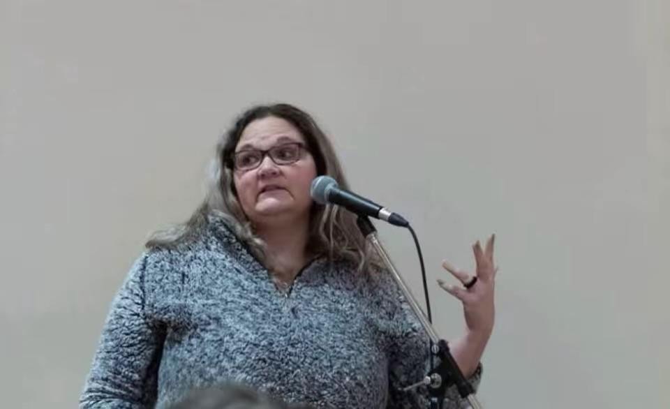 Carmela speaking at a community microphone